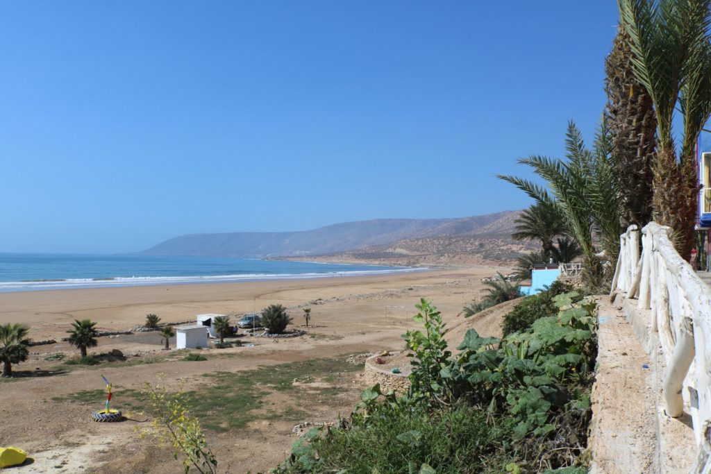 A wave breaking at Desert Point, Morocco, with the rugged coastline in the background.