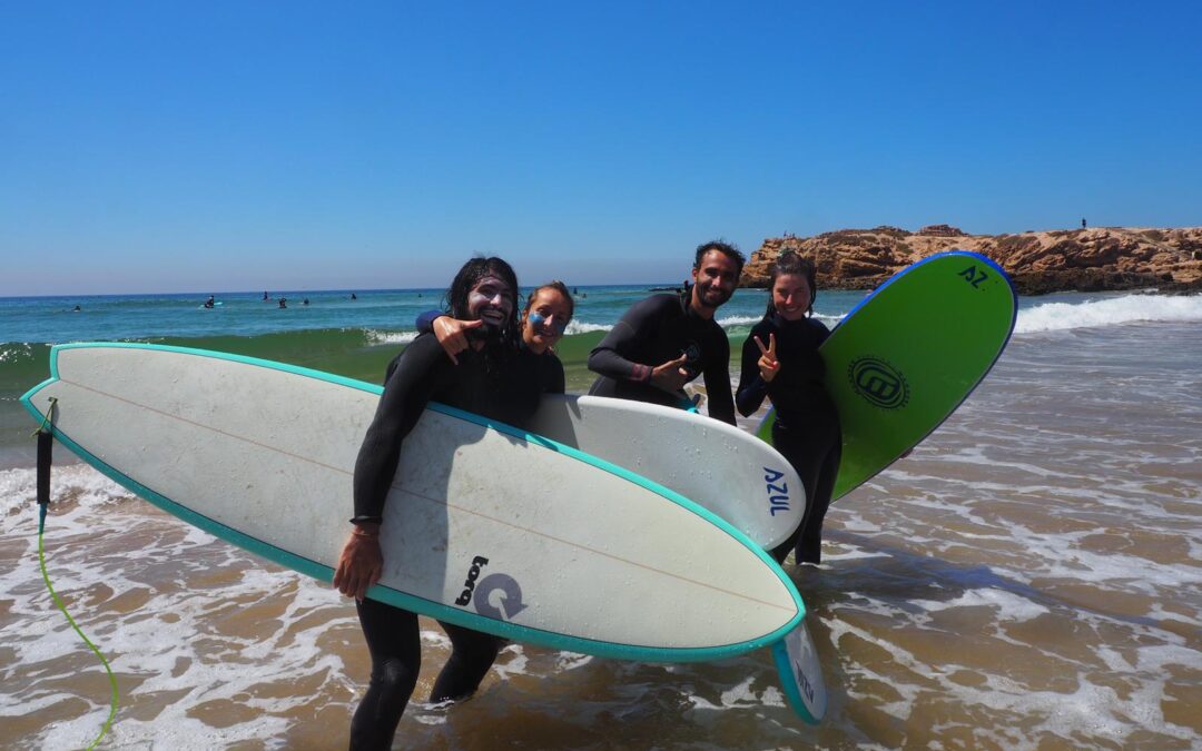 Surfeurs tenant leurs planches de surf sur la plage a Tamraght près de Taghazout au Maroc, après une épique session de surf