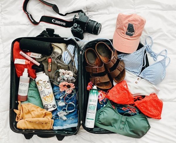 Traveler organizing light clothing for a surf vacation in Morocco.