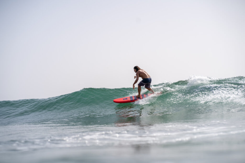 Hucine, instructor and owner of Azul Guesthouse, catching a nice wave at Crocro Beach, Tamraght, Morocco.