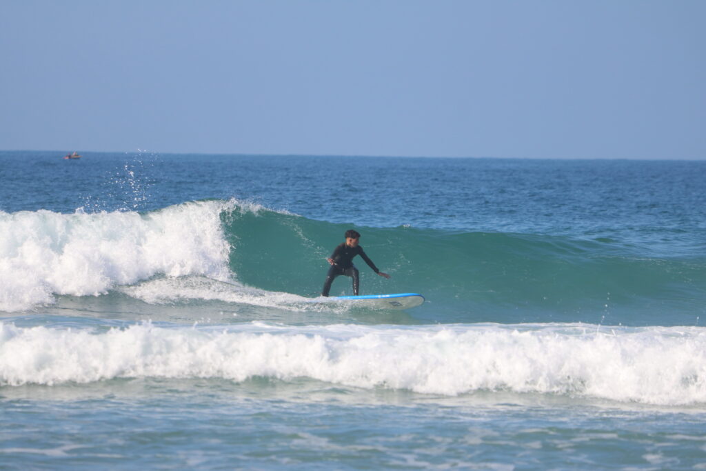 Azul Guesthouse coach surfing a perfect left wave at Crocro Beach, showcasing the pristine surf conditions of the Moroccan coastline.