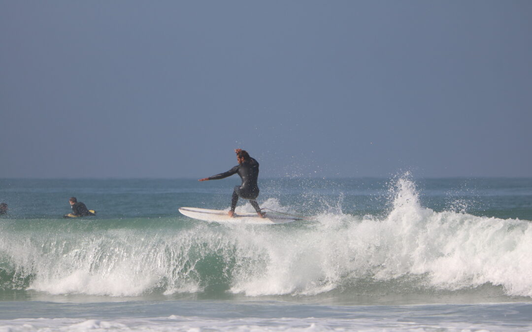 Surfer performing a floater on a wave at KM 17 near Taghazout, Morocco.